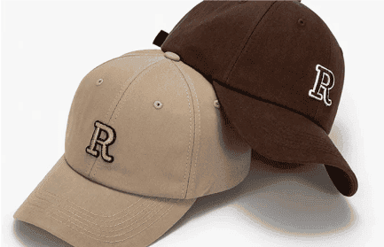 3D embroidered hats in natural color and brown, featuring the letter "R" embroidered on the front panel. The 3D embroidery pops out from the surface of the hat, giving the letter a unique and textured appearance against the hat's neutral tones. The custom 3D embroidery adds a personalized and stylish touch to the hats, making them a standout accessory for any outfit.